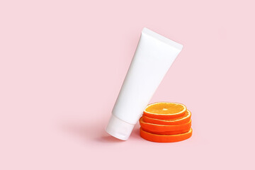 Cream tube with vitamin c branding concept and orange slices on pink background. Cosmetic skincare product blank plastic package. White unbranded lotion, balsam, hand creme, toothpaste mockup. - obrazy, fototapety, plakaty