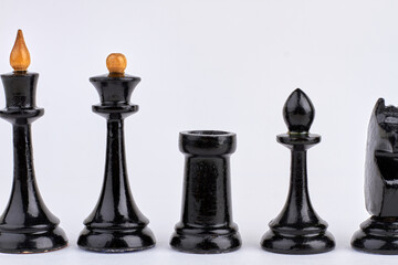 Black wooden chess pieces isolated on white background.