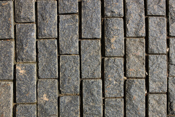 Fragment of the road paved with an old granite stone