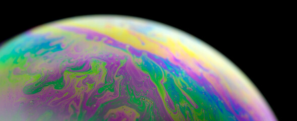 Blurred Colourful soap bubble close up. Macrophotography of bubbles. Caused by the interference of light, and creating a dream-like image on the surface of bubbles.