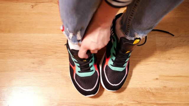 Woman puts on sneakers and shoe laces befor do sport exercise or run activity