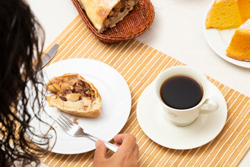 Young woman doing a strudel, with coffee.