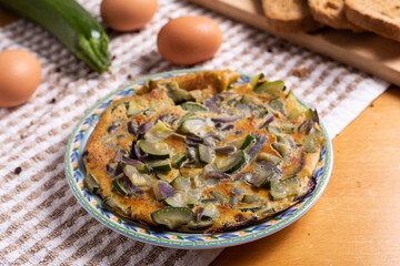 Zucchini and onion omelette served with bread. Complete vegetarian dish.