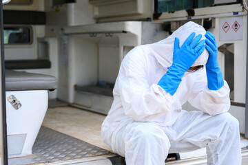 Health worker Standing at an emergency ambulance Wear a PPE uniform Ambulances carry the bodies of...