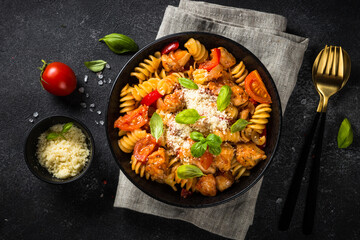 Pasta chicken with vegetables on black.