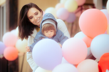 Fototapeta na wymiar Happy Mother and Child Enjoying Colorful Balloons