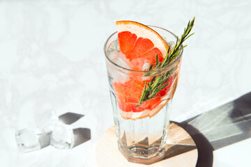 mineral water in a glass with grapefruit and rosemary