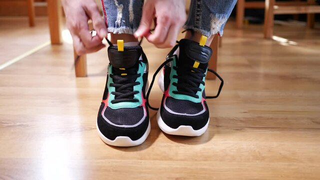 Woman puts on sneakers and shoe laces befor do sport exercise or run activity