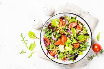 Green salad with fresh vegetables at white.
