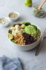 Bowl with avocado, black rice, chickpeas, cabbage, spinach and salad. Healthy eating. Vegetarian food.