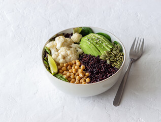 Bowl with avocado, black rice, chickpeas, cabbage, spinach and salad. Healthy eating. Vegetarian food.