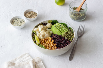 Bowl with avocado, black rice, chickpeas, cabbage, spinach and salad. Healthy eating. Vegetarian food.