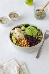 Bowl with avocado, black rice, chickpeas, cabbage, spinach and salad. Healthy eating. Vegetarian food.