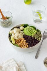 Bowl with avocado, black rice, chickpeas, cabbage, spinach and salad. Healthy eating. Vegetarian food.