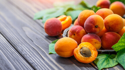 Delicious ripe apricots in a wooden bowl on the table close-up.Healthy fruits. Horizontal top view. Free space for your text.