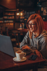 Woman working on her laptop w in a cafe