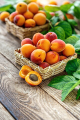 Delicious ripe apricots in a wooden bowl on the table close-up.Healthy fruits. Horizontal top view. Free space for your text.