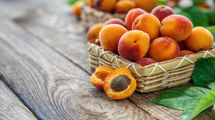 Delicious ripe apricots in a wooden bowl on the table close-up.Healthy fruits. Horizontal top view. Free space for your text.