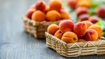 Delicious ripe apricots in a wooden bowl on the table close-up.Healthy fruits. Horizontal top view. Free space for your text.