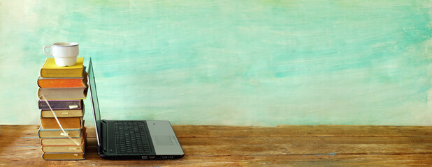 Stack of books and laptop computer,home office, homeschooling,reading,education, business concept....