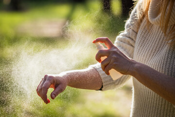 Insect repellent. Woman tourist applying mosquito repellent on hand during hike in nature. Skin...