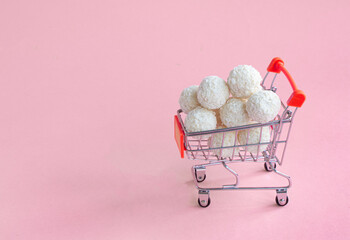 coconut round candies in a mini shopping basket, isolate on
