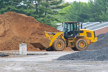 A close-up excavator loads soil into the bucket for further road installation shovel