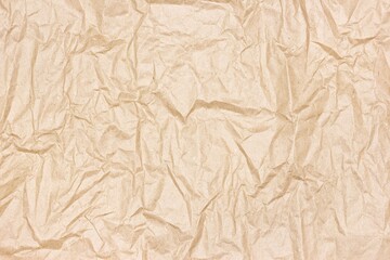 Crumpled kraft packing paper texture. Recycled brown paper sheet - top view. Abstract background