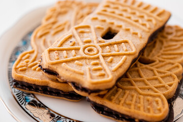 Beautifully illustrated biscuits with dark chocolate on a Herend porcelain plate.