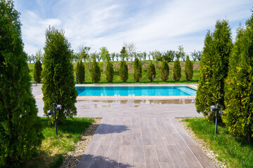 a walkway lined with tiles to the pool between the trees. rest in the countryside. Spa or country club