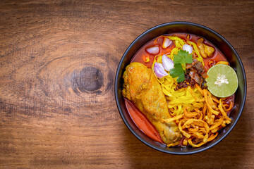 Khao Soi Gai, Thai Noodles Khao Soi, Chicken Curry with seasoning on wooden floor, Northern Thai food concept. (Lanna food)