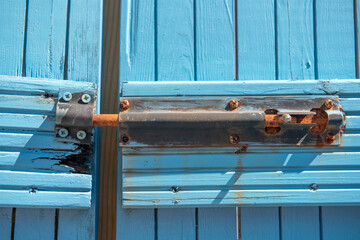 Close up of old rusty lock on blue door 