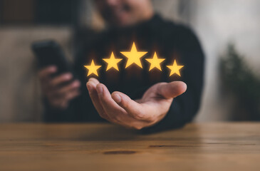 hand of customer or client holding the stars to complete five stars. with copy space. giving a five...