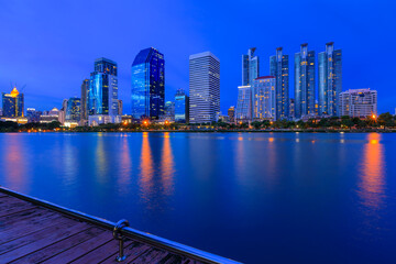 Obraz premium modern buildings of Bangkok night city skyline, Thailand. Cityscape photography of Benchakitti Park at dusk. Bangkok night city downtown. Modern night city skyline with lights reflection, Asia