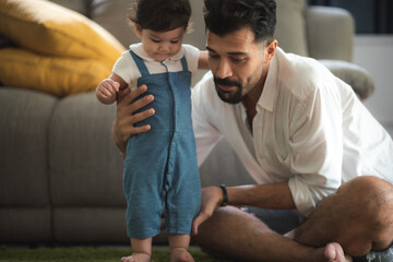 cute toddler little child family concept, baby learning to walk with father and mother to help care and holding hand, first step with childhood parent support, small love portrait little boy at home