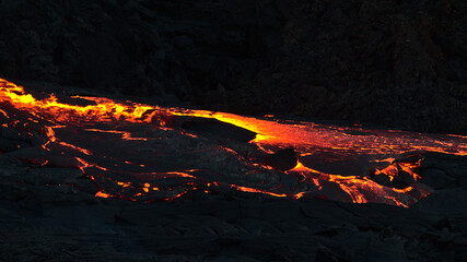 Beautiful view of volcanic eruption in Geldingadalir valley near Fagradalsfjall mountain, Grindavík, Reykjanes peninsula, southwest Iceland with flowing and glowing lava river in the dark.