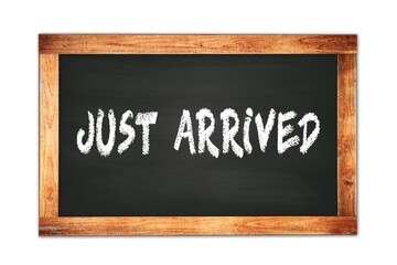 Fototapeta premium JUST ARRIVED text written on wooden frame school blackboard.