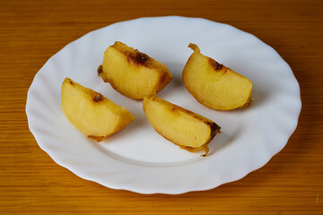 Naklejka na ściany i meble Tasty Baked Apple slices on a plate and wooden background