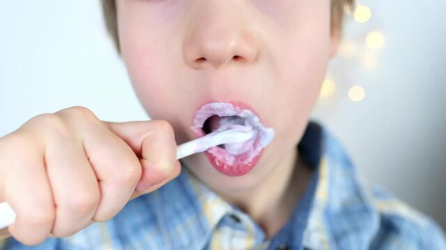 child, kid 6-7 years old diligently brushes teeth and colored children's paste, dental concept, oral hygiene, daily morning routine