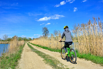 Obraz na płótnie Canvas Woman riding a bicycle on a sunny spring day. Outdoor recreation.