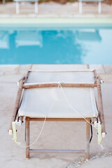 Obraz na płótnie Canvas Folded deck chairs near a swimming pool in a garden