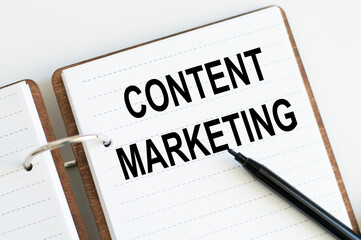 of Content Marketing world in notebook on light background near black marker