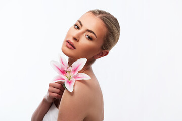 Beautiful woman holding a beautiful pink lily flower on white background 