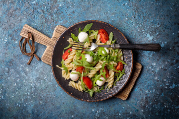 Pasta with cherry tomatoes, soft cheese and arugula leaves