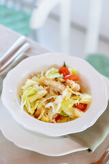 Caesar salad with baked chicken breast, cherry tomatoes, iceberg lettuce and croutons, Provencal herbs and Caesar sauce. Quail eggs with parmesan. Serving a plate on a table with a tablecloth