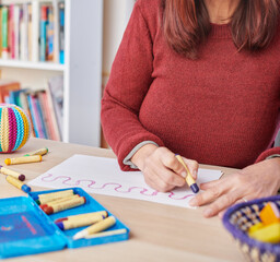 Woman painting with crayons on desk