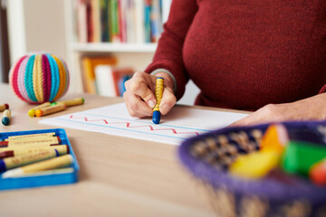 Woman painting with crayons on desk