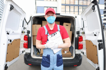 Male courier in protective medical mask delivers parcels