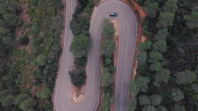 Vista a&eacute;rea de coche en carretera con curvas y con paraje natural