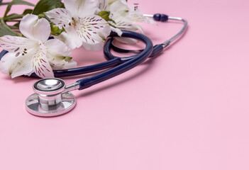 a stethoscope and a bouquet of alstroemeria on a pink background. Happy Nurse's Day